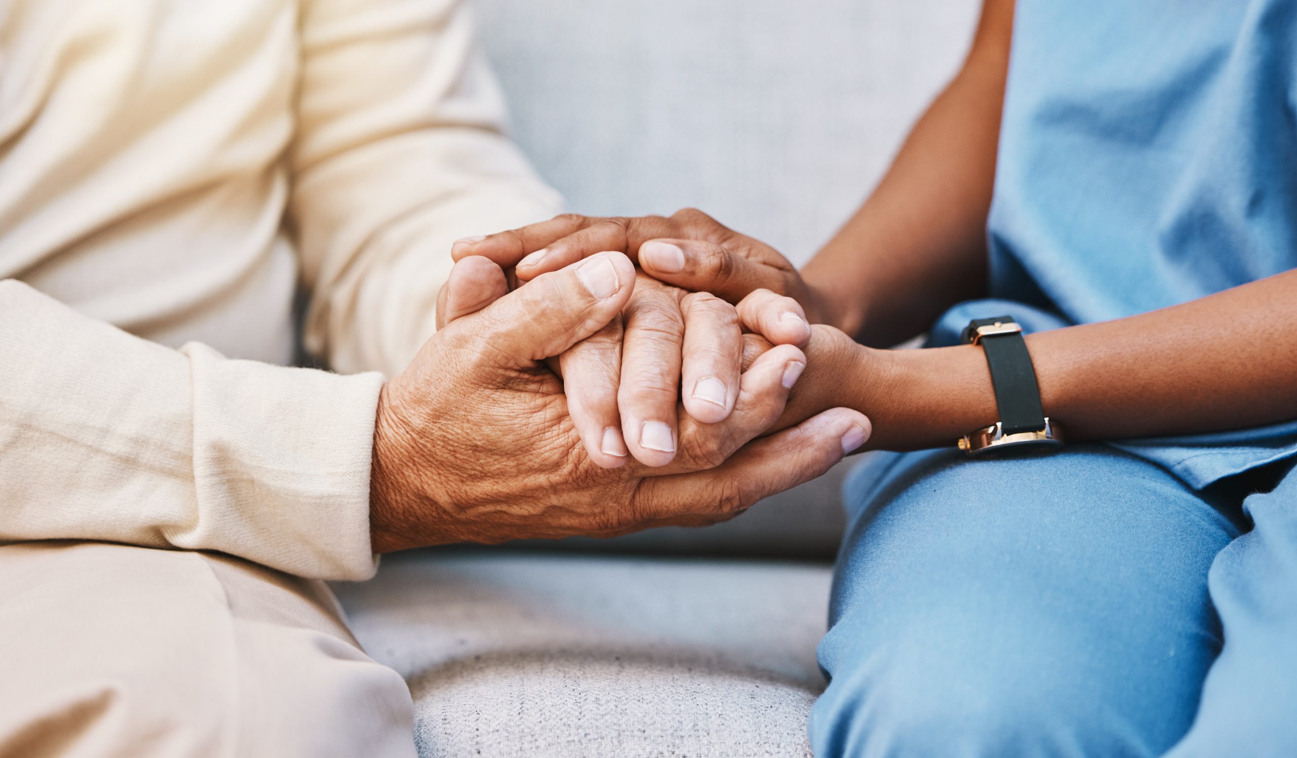 Nurse holding hands with senior living resident